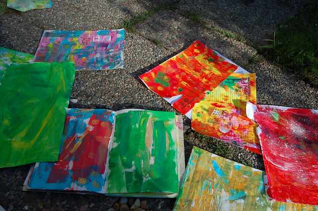Painted background paper spread out on the ground outdoors