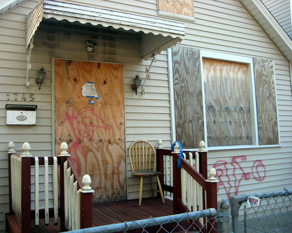 Image of Boarded up home with graffiti on it