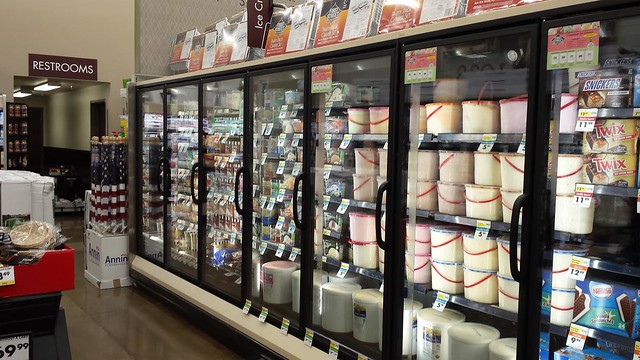 A grocery store isle with ice cream on the shelves.