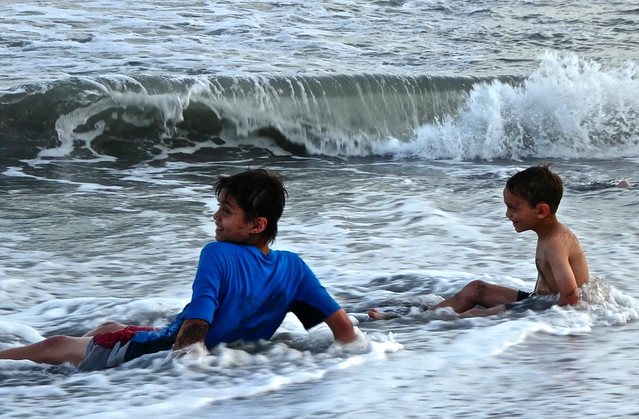 two kids having fun in the waves of monterrico beach