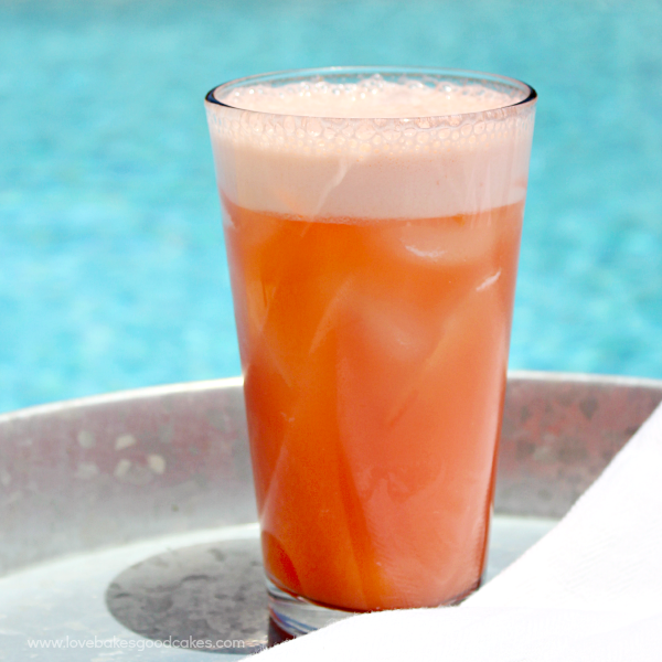 June Bug Drink in a glass near the edge of a pool.