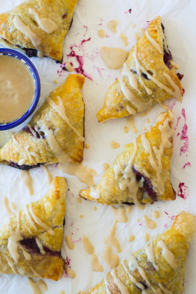 These sweet bourekas are filled with sweet apples and blueberries and drizzled with a creamy and sweet honey tahini sauce. A sweet twist on a popular Mediterranean treat. These little pastries are fast, easy and perfectly sweet. 