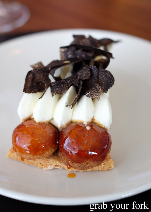 Profiteroles filled with hazelnut cream encircling the black truffle St Honore at Sixpenny in Stanmore